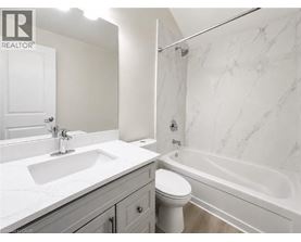 A white bathroom with a marble patterned wall.
