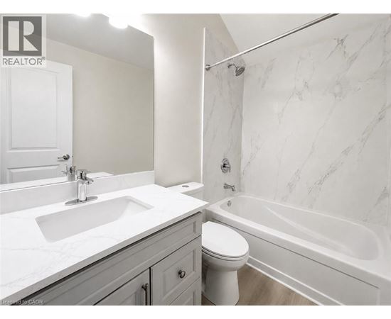 A white bathroom with a marble patterned wall.