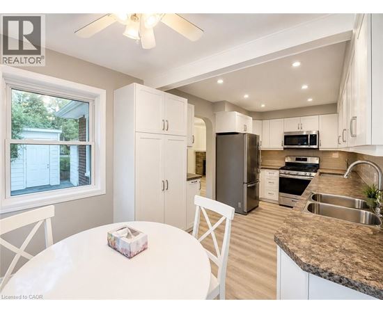 A well-lit kitchen with a table and chairs.