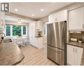 A modern kitchen with a stainless steel refrigerator and white cabinets.