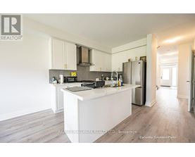 A kitchen with white cabinets and a white island.
