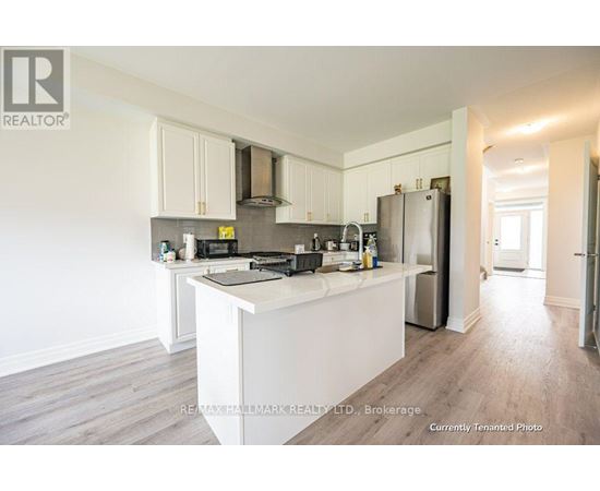 A kitchen with white cabinets and a white island.