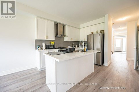 A kitchen with white cabinets and a white island.