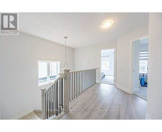 A spacious room with a staircase leading to the second floor.