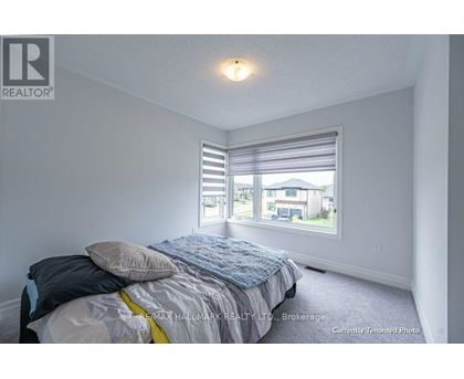 A bedroom with a bed and a window with blinds.
