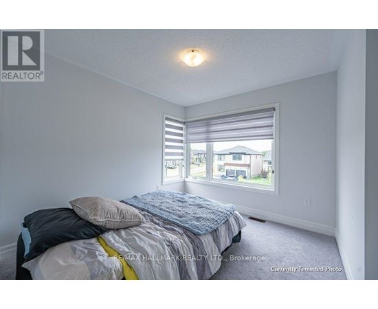 A bedroom with a bed and a window with blinds.