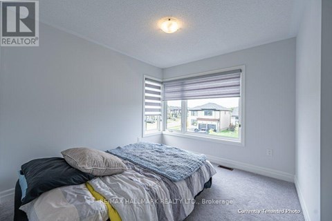 A bedroom with a bed and a window with blinds.