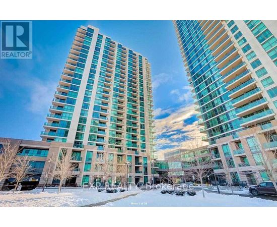 Two tall buildings with glass windows and balconies are surrounded by bare trees and snow.