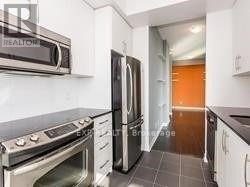 A kitchen with a stove top oven and a refrigerator.