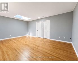A room with wooden flooring and two white doors.