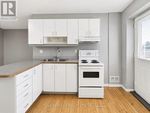 A kitchen with white cabinets and a wooden counter top.