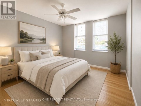 A bedroom with a bed, a ceiling fan, and a painting on the wall.