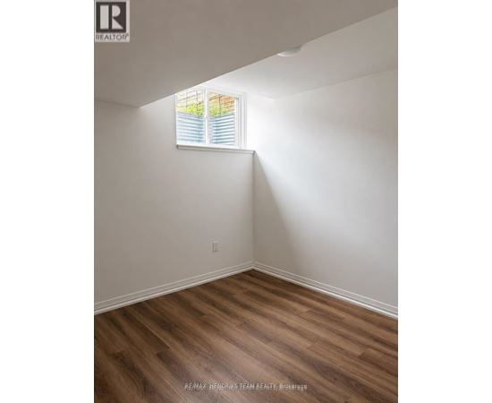 A room with a window and wooden flooring.