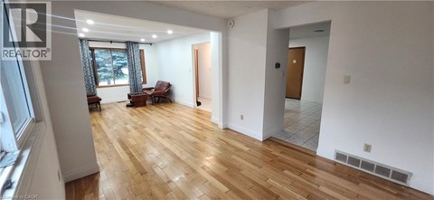 A large, empty room with wooden floors and white walls.