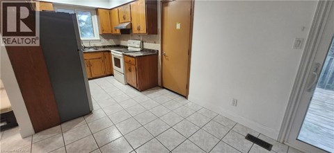 A kitchen with a refrigerator and a sink.