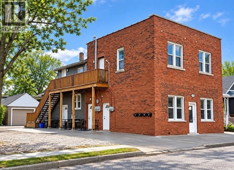 A red brick house with a white door and windows.