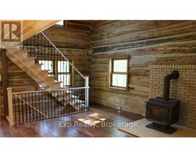 A wood stove is in a room with wooden walls.