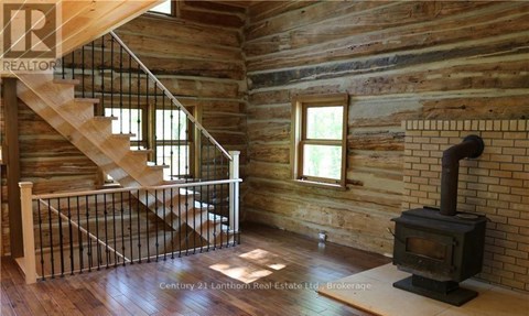 A wood stove is in a room with wooden walls.
