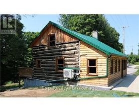 A wooden house with a green roof is for sale.