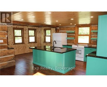 A kitchen with a white fridge and black countertops.