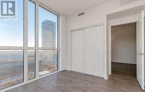 A room with a view of a cityscape through large windows.