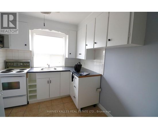 A kitchen with white cabinets and a stove top oven.