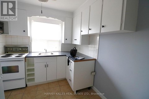 A kitchen with white cabinets and a stove top oven.