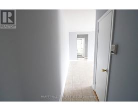 A hallway with a door on the right and a wall on the left.