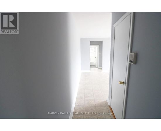 A hallway with a door on the right and a wall on the left.