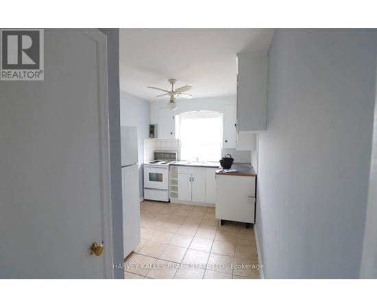 A white kitchen with a fan on the ceiling.