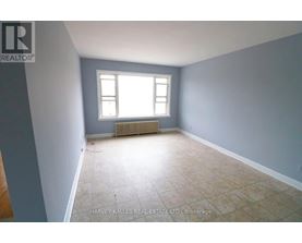A room with a window and a radiator on the floor.