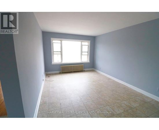 A room with a window and a radiator on the floor.