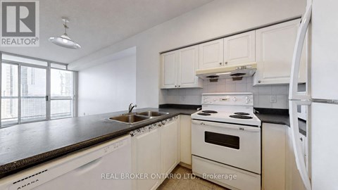 A modern kitchen with white cabinets and appliances.