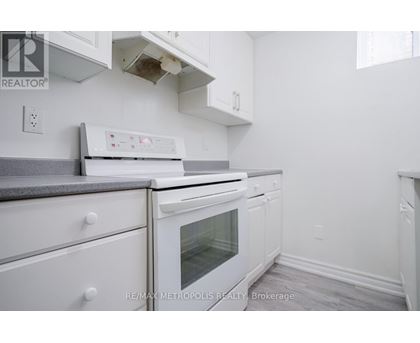 A white kitchen with a stove top oven and a microwave.
