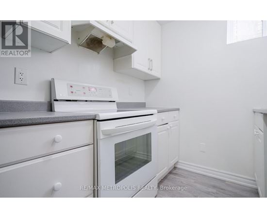A white kitchen with a stove top oven and a microwave.