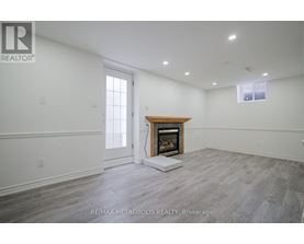A spacious room with a fireplace and a large window.