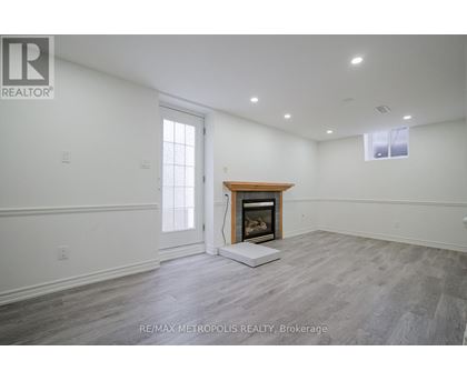 A spacious room with a fireplace and a large window.