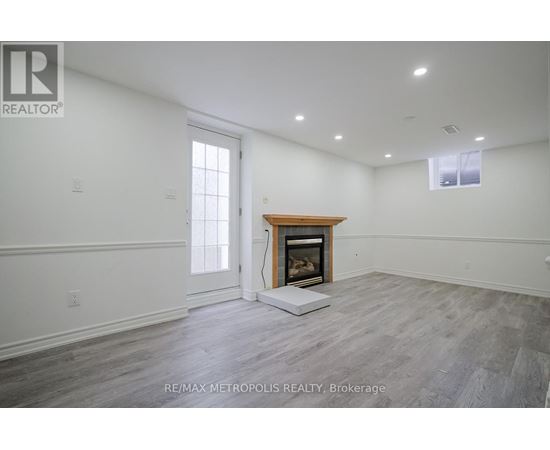 A spacious room with a fireplace and a large window.
