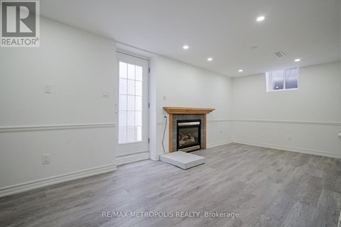A spacious room with a fireplace and a large window.