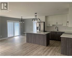 A modern kitchen with a large island and a refrigerator.