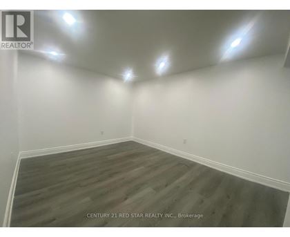 A room with wooden flooring and white walls.