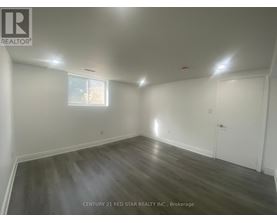 A room with wooden flooring and white walls, with a window and a door.