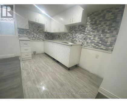 A kitchen with a checkered backsplash and wooden flooring.