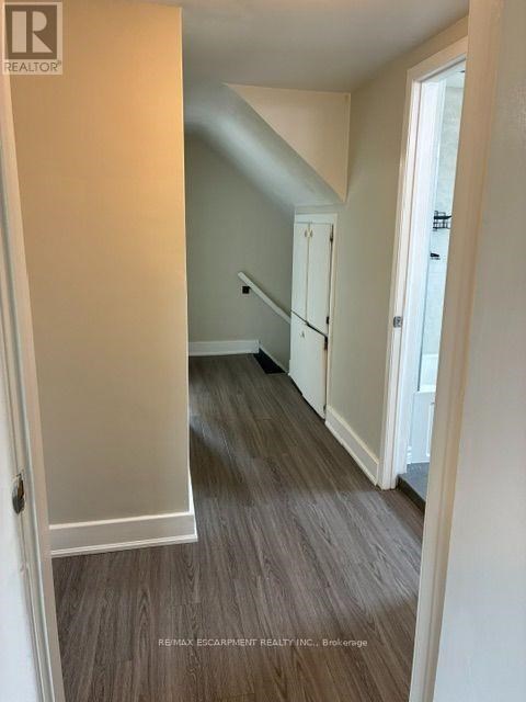 A hallway with a wooden floor and white walls.
