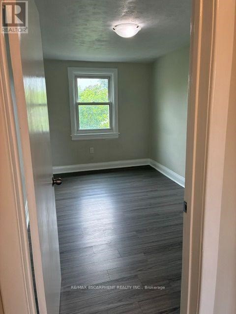 A room with a window and wooden flooring.
