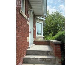 A house with a white door and a brick wall.