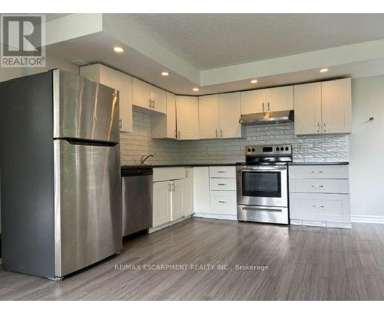 A modern kitchen with stainless steel appliances and white cabinets.