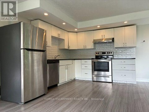 A modern kitchen with stainless steel appliances and white cabinets.