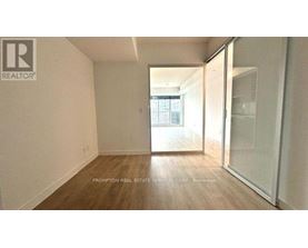 A room with a sliding glass door leading to a balcony.