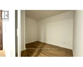 A room with wooden flooring and white walls.